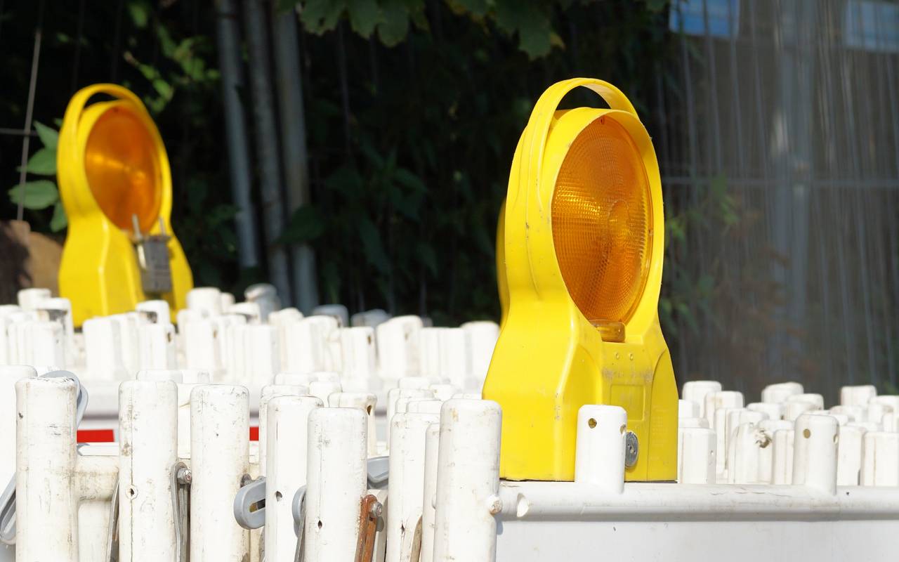 Hintereinander stehend gestapelte Absperrungen für Straßensperrungen mit zwei Lichtern.