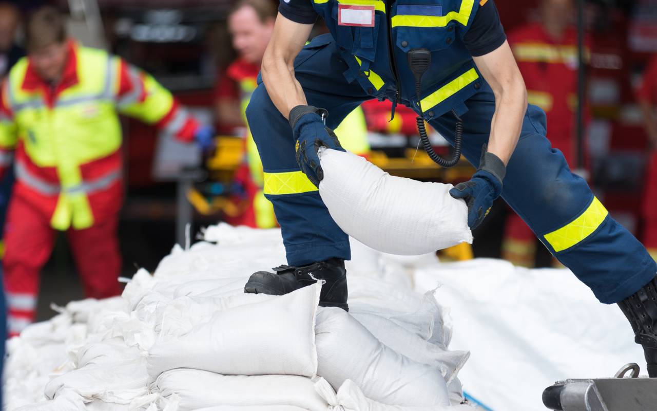 Ein Helfer transportiert Sandsäcke (Symbolbild). Bei Verwendung in Social Media muss die Bildquelle am Bild genannt werden; bei Verwendung als Nachrichtenbild spielt das System diese automatisch mit aus.