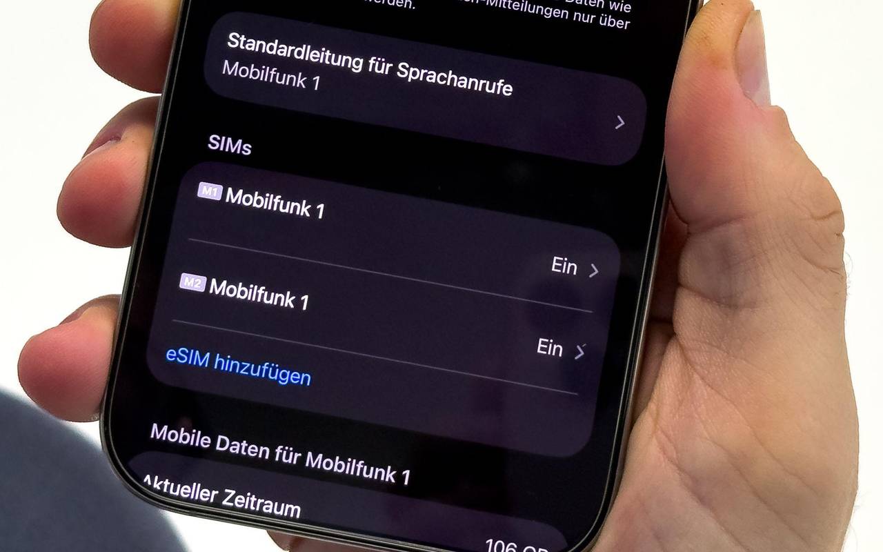 Ein Mann aendert die SIM-Karten-Einstellungen auf einem iPhone