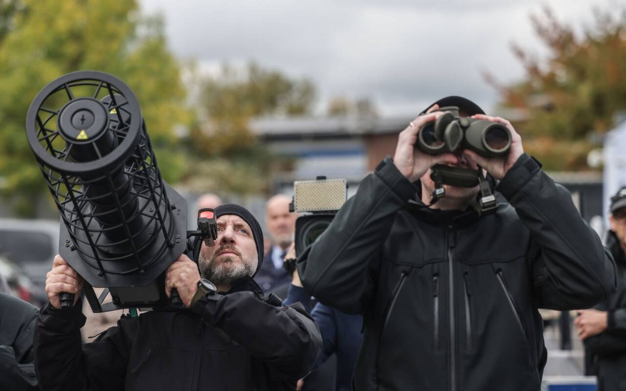 Polizisten der Drohnenabwehr peilen mit einem Jammer (l) und einem Fernglas (r) bei einer Vorführung eine Drohne an. Die Polizei in Nordrhein-Westfalen hat ihre Möglichkeiten zur Drohnenabwehr vorgestellt.