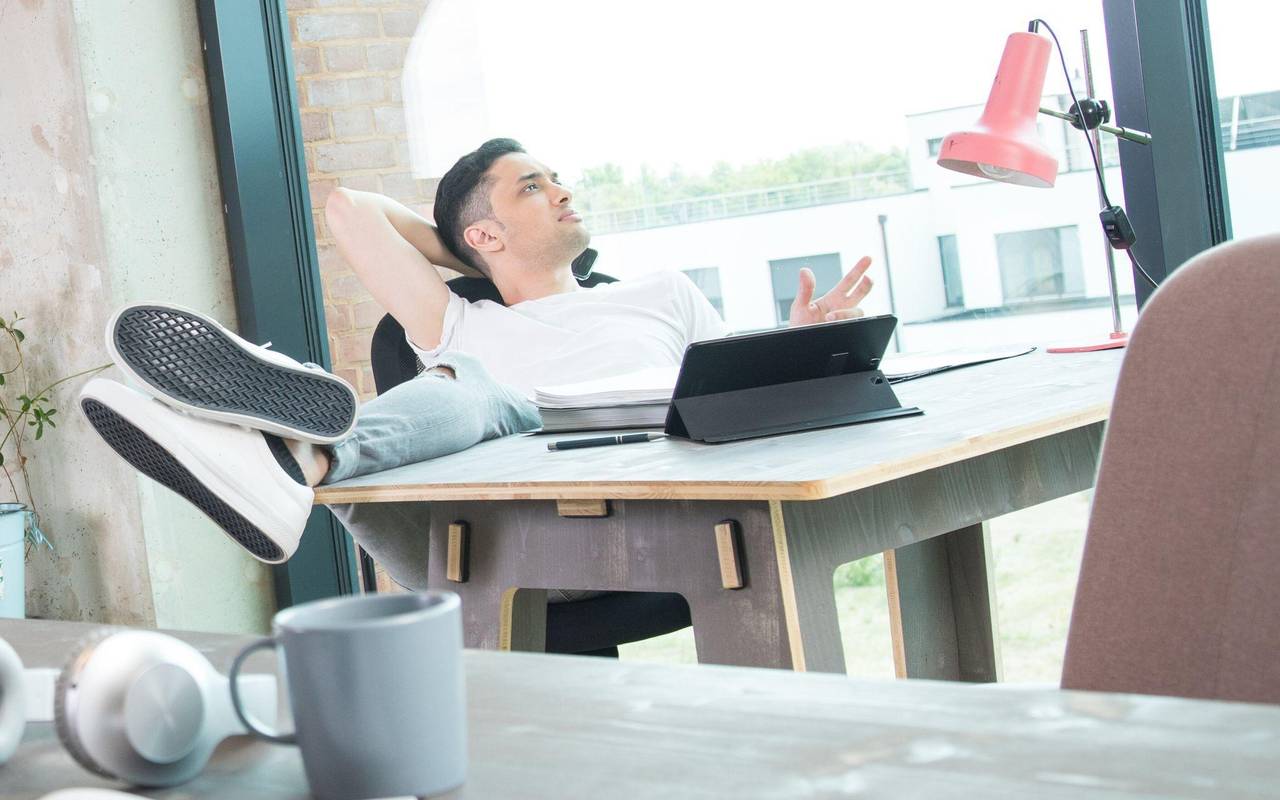 Mann schaut an seinem Schreibtisch aus dem Fenster