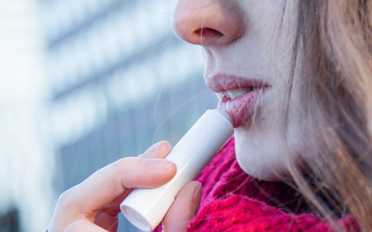 Frau trägt eine Lippenpflege auf