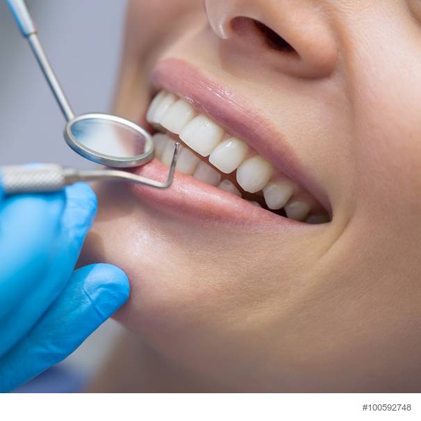 Ein Zahnarzt untersucht eine Patientin im Behandlungszimmer.