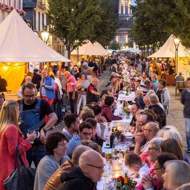Auf dem Bild ist die lange Tafel in der Altstadt von Arnsberg zu sehen, an dem die Leute gemeinsam verschiedenste Gerichte verspeisen.