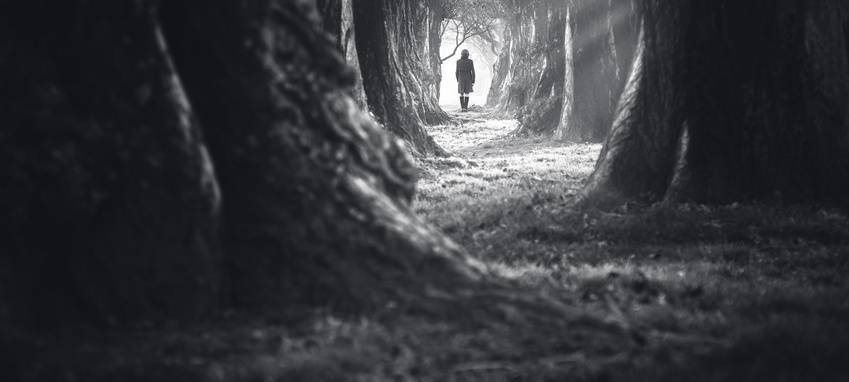 Eine Frau läuft einen einsamen Weg entlang (Symbolbild).