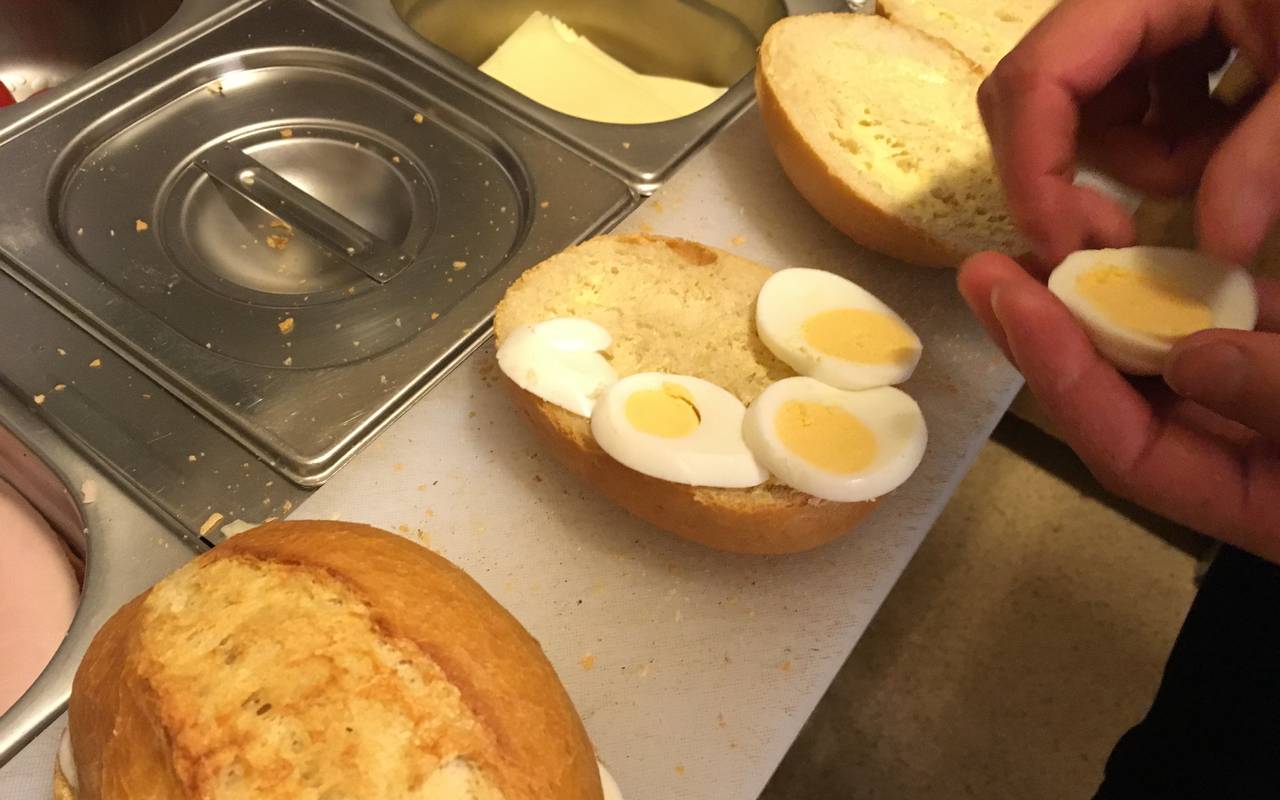 Brötchenschmieren in der Bäckerei Junker in Sundern-Hachen, hier ein Brötchen belegt mit quergeschnittenem Ei. Die Brötchen werden in drei Brötchenautomaten verkauft, die in zwei Sunderner Firmen stehen.