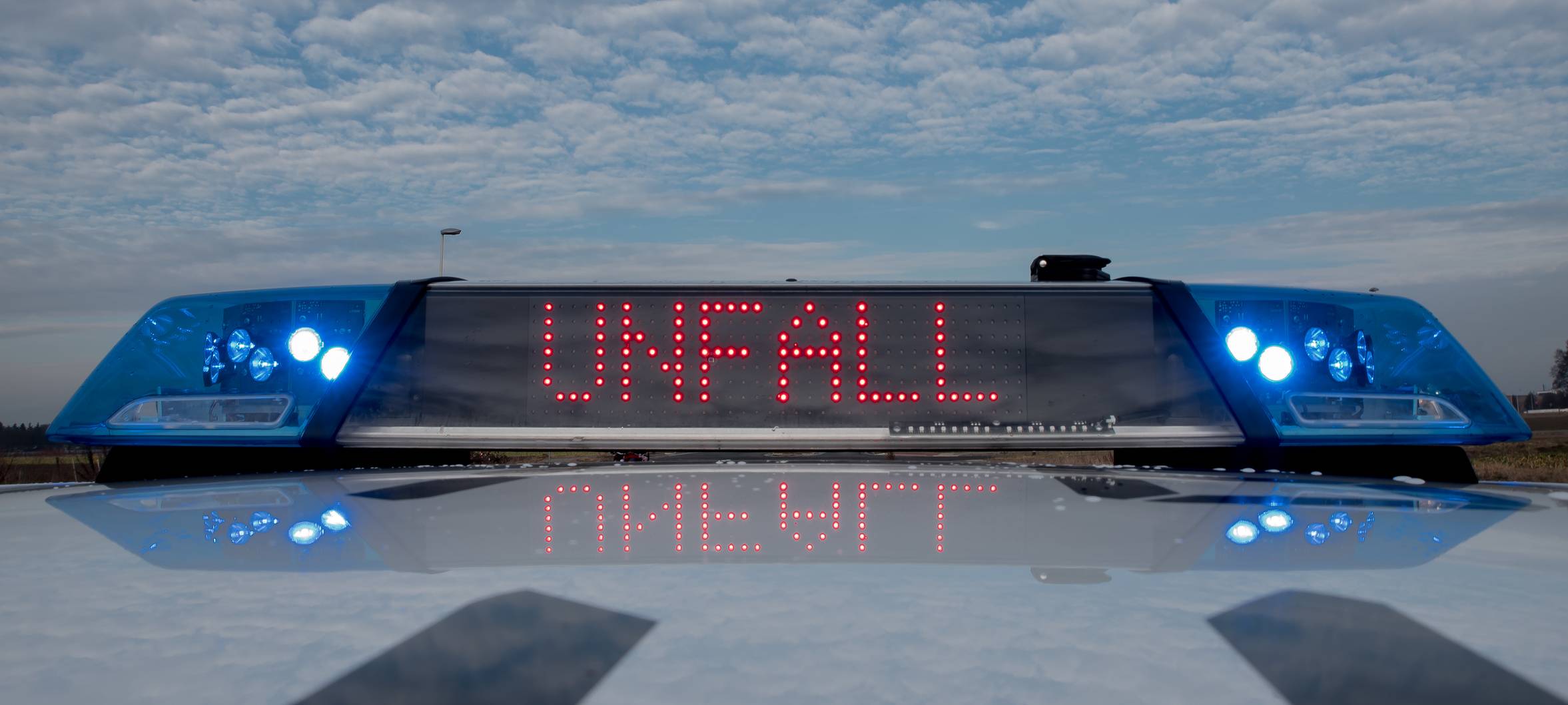 Ein Einsatzwagen der Polizei mit Blaulicht und aktivem Schriftzug "Unfall" (Symbolbild). Bei Verwendung in Social Media muss die Bildquelle am Bild genannt werden; bei Verwendung als Nachrichtenbild spielt das System diese automatisch mit aus.