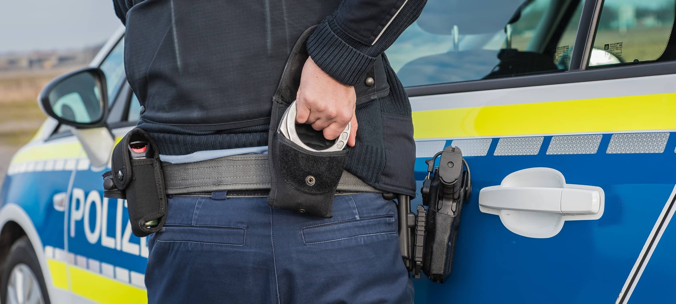 Ein Polizist nutzt Handschellen zur Festnahme (Symbolbild). Bei Verwendung in Social Media muss die Bildquelle am Bild genannt werden; bei Verwendung als Nachrichtenbild spielt das System diese automatisch mit aus.