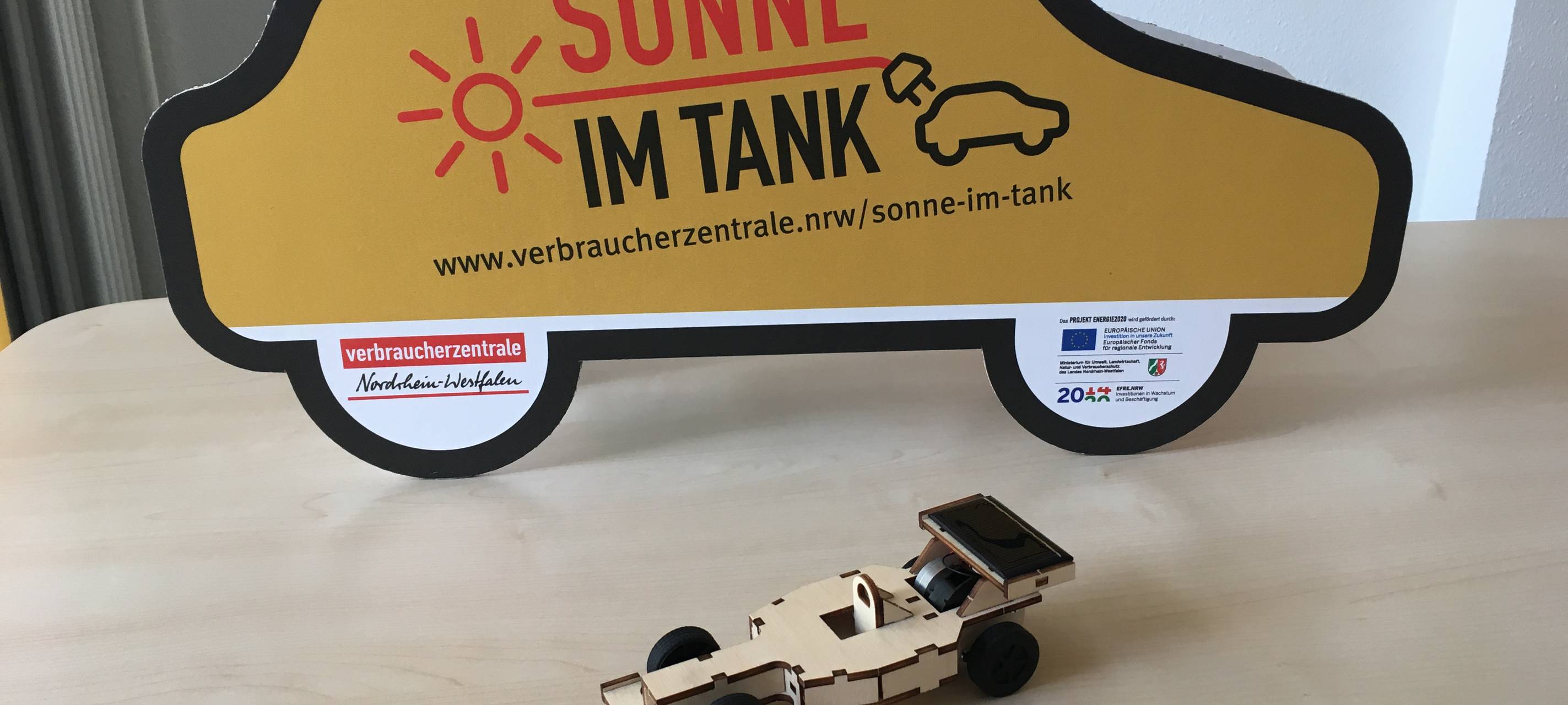 "Sonne im Tank" ist eine Aktion der Vebraucherzentrale in Neheim. Das Holzauto gibt es als Bausatz zur Demonstration.