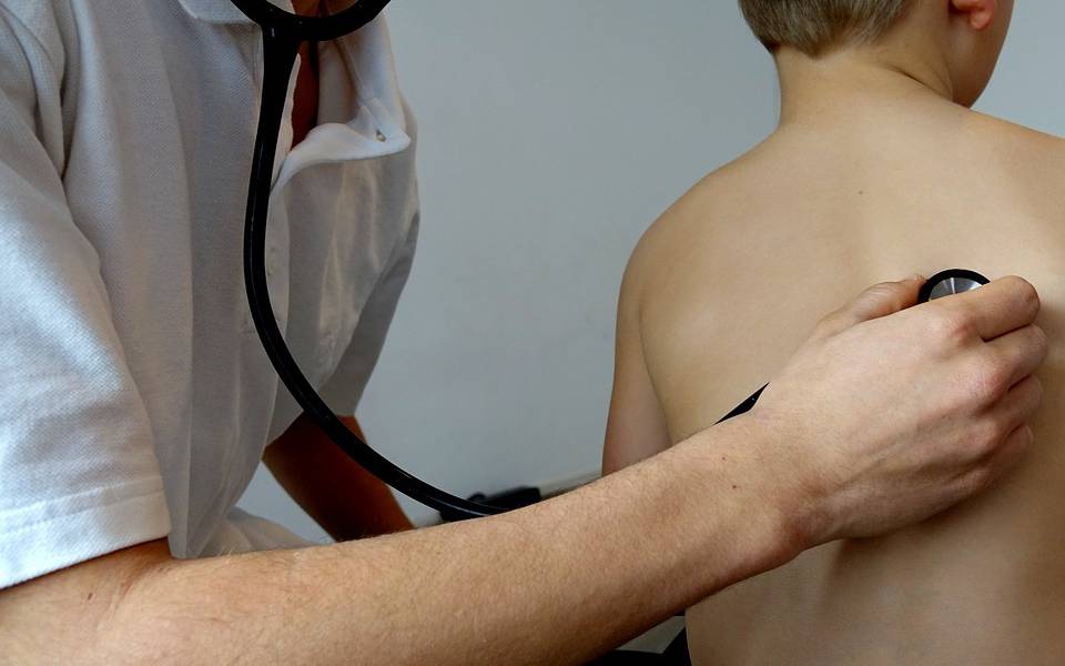 Symbolfoto eines Arztes, der mit dem Stethoskop ein Kind abhört.