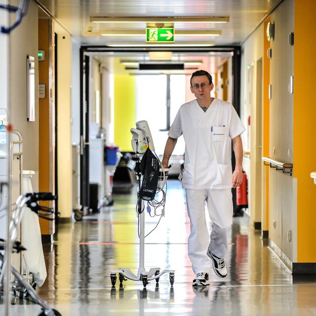 Ein Krankenpfleger geht über den Gang in einer Station des Universitätsklinikums Essen.