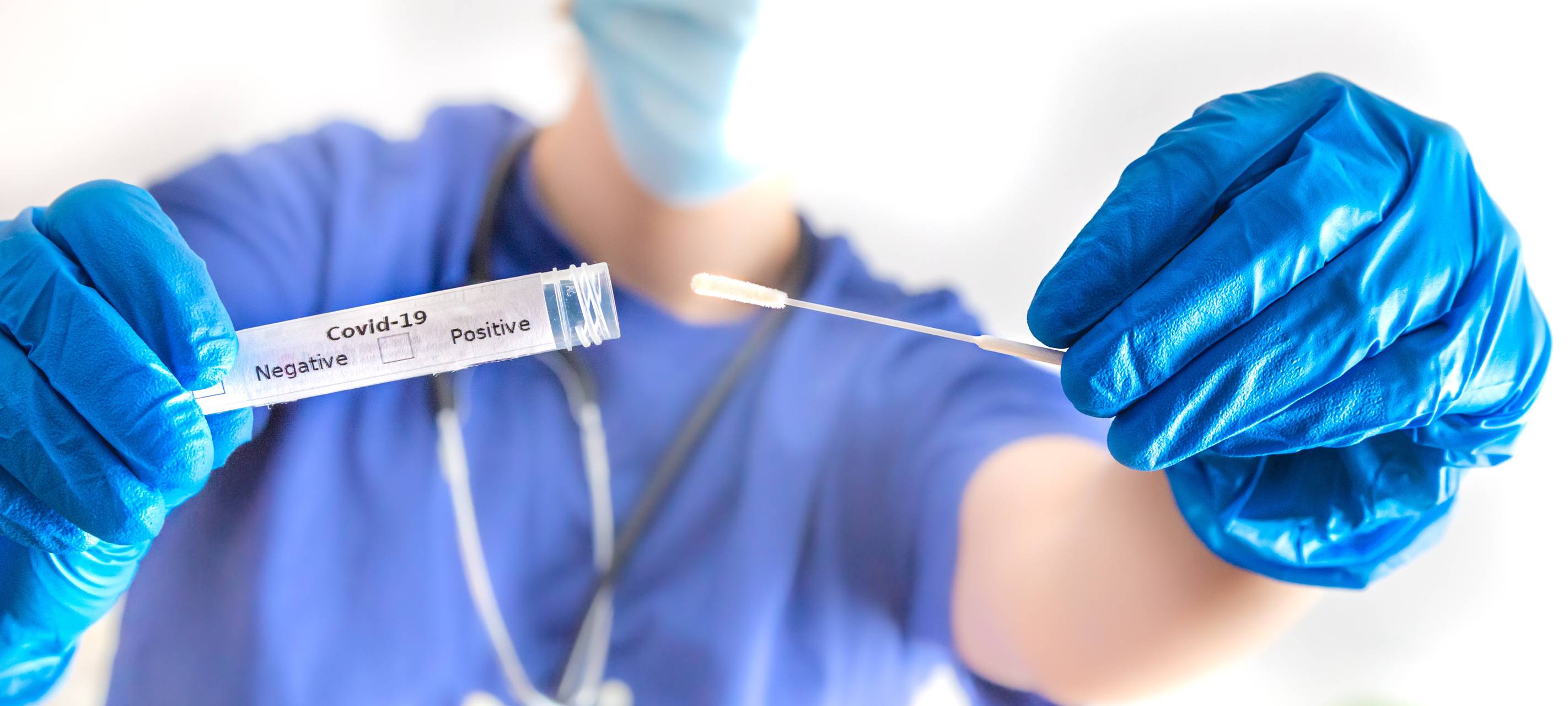 Ein Arzt hält eine Coronavirus-Abstrichröhre in der Hand.