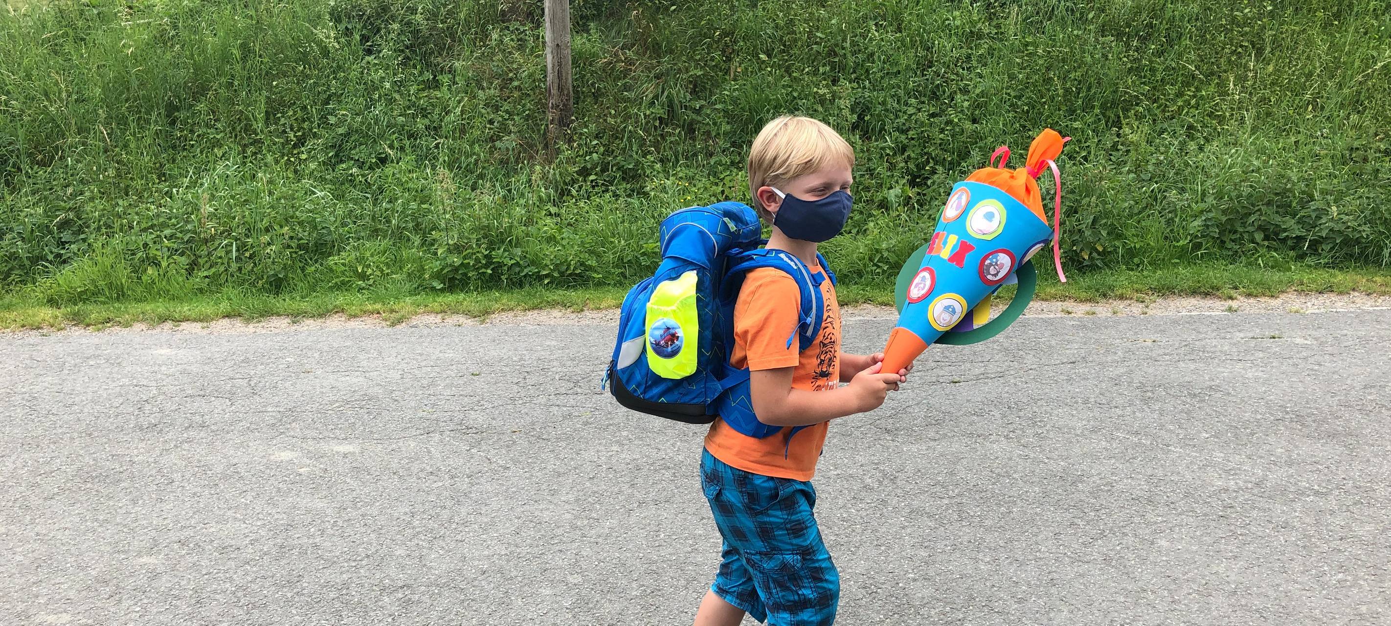 Einschulung: Mit Schultüte und Maske