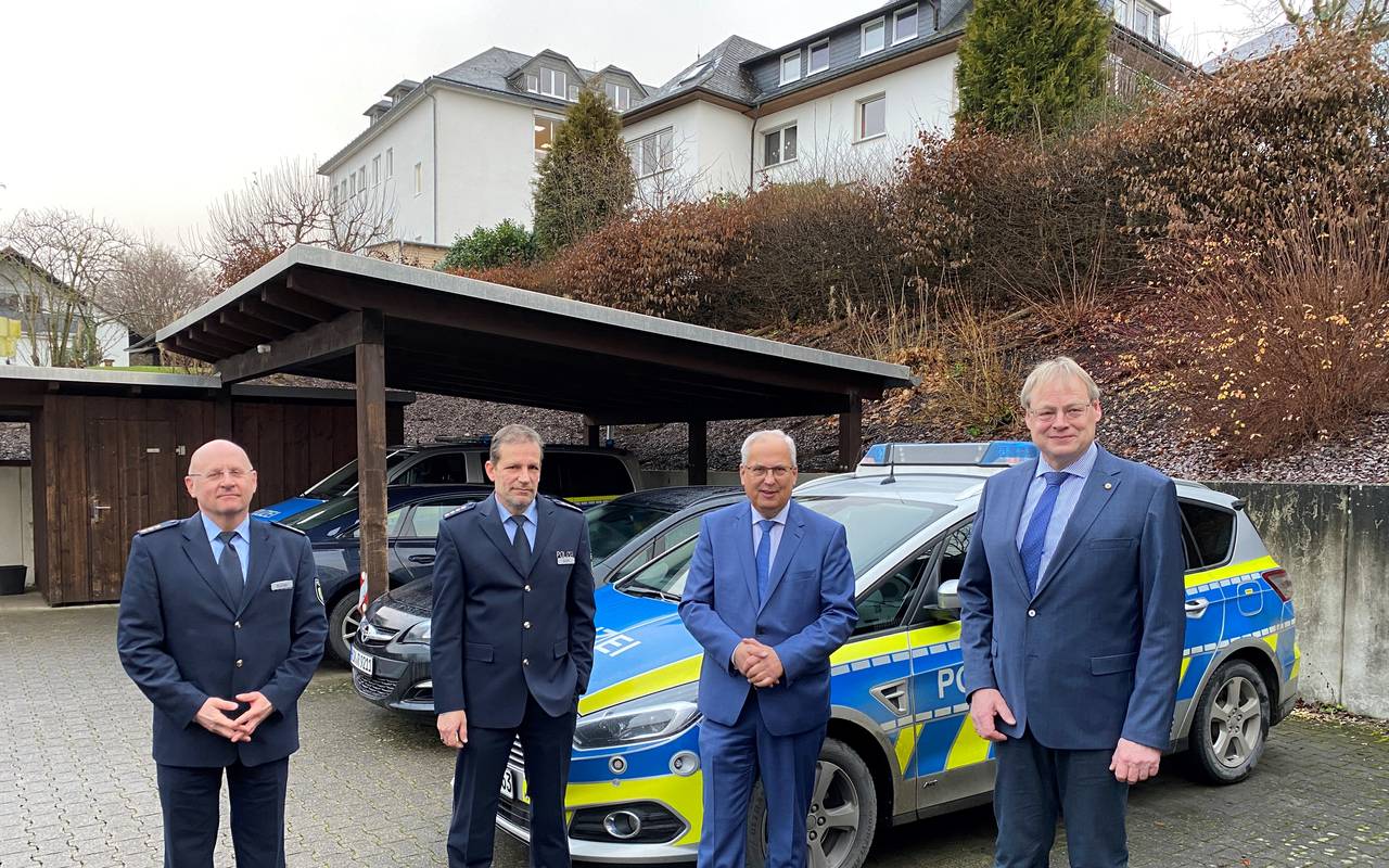 Polizeidirektor Klaus Bunse, Polizeihauptkommissar Ludger Rath, Landrat Dr. Schneider und Bürgermeister Burkhard König stehen vor einem Streifenwagen.