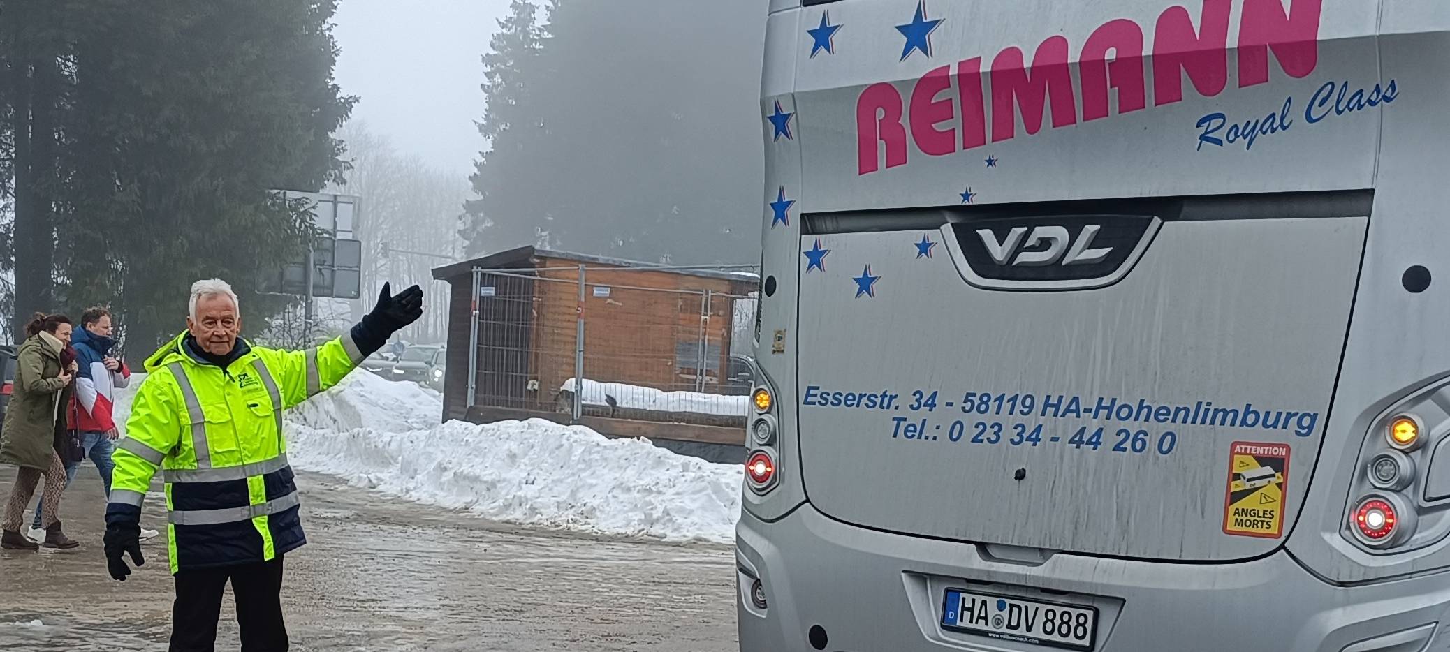 Parkplatzwächter Manni Hirsch weist Bus ein