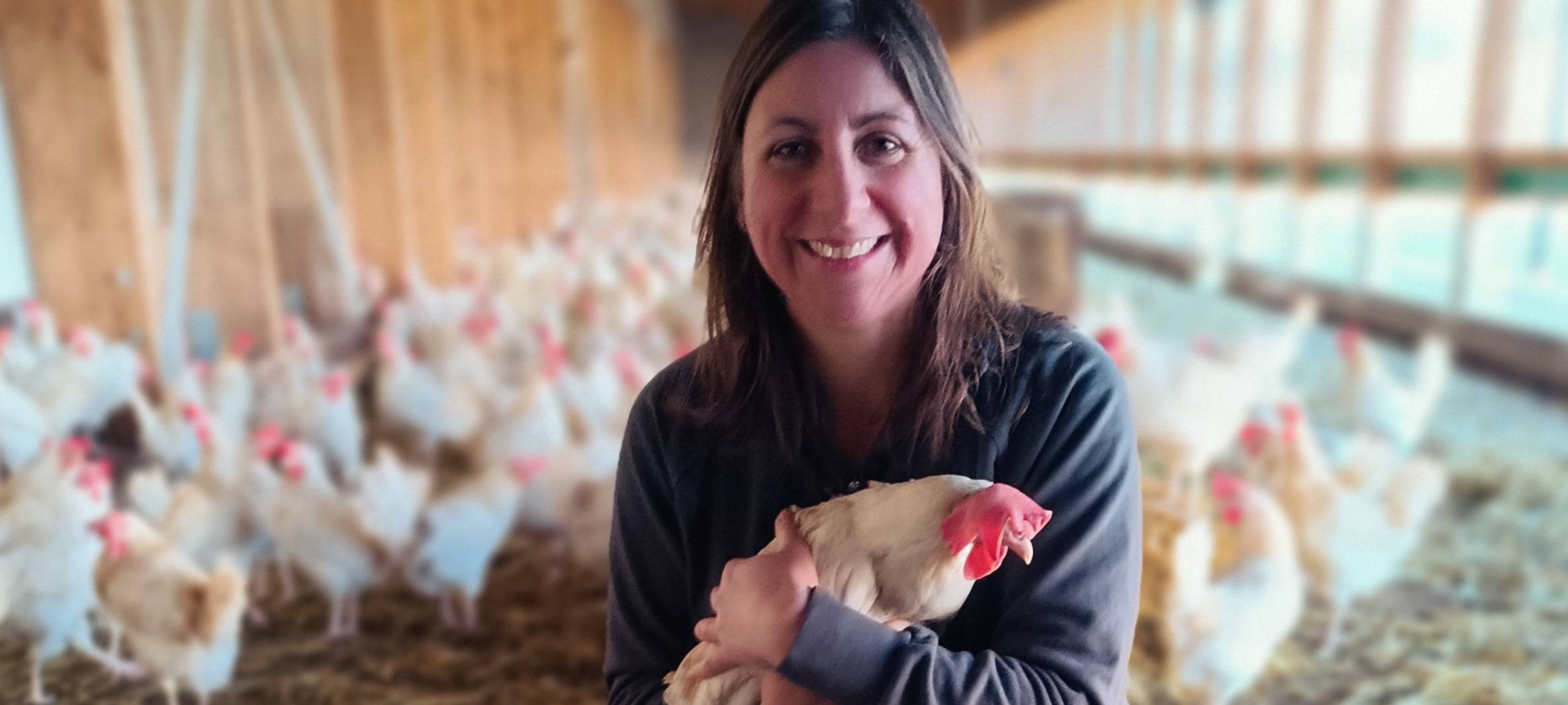 Ina Althaus mit Huhn in offenem Hühnerstall